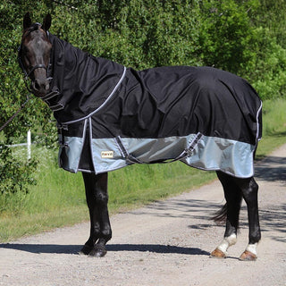 Svart häst står på en grusväg en sommardag. Hästen har på sig nova 100 grams täcke med löstagbar hals. 