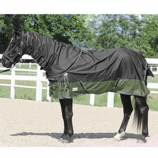 En svart häst står i gruspaddocken och har på sig nova regntäcke med fleecefoder. Täcket har löstagbar hals och är i färgen grey olive green. 